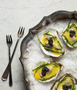 oysters prepared with sabayon sauce and sea beans presented on a bed of sea salt